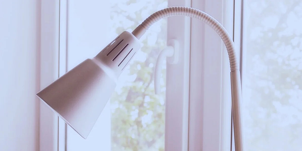 Weiße Schreibtischlampe vor einem Fenster