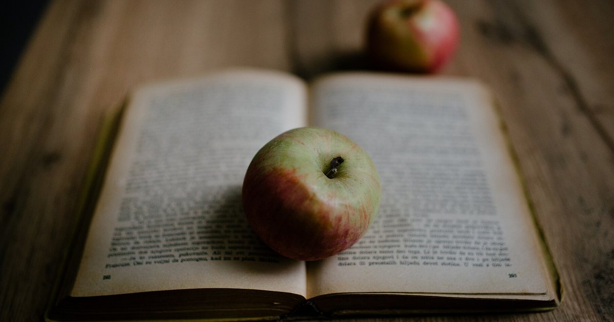 Buch und Äpfel auf einem Holztisch